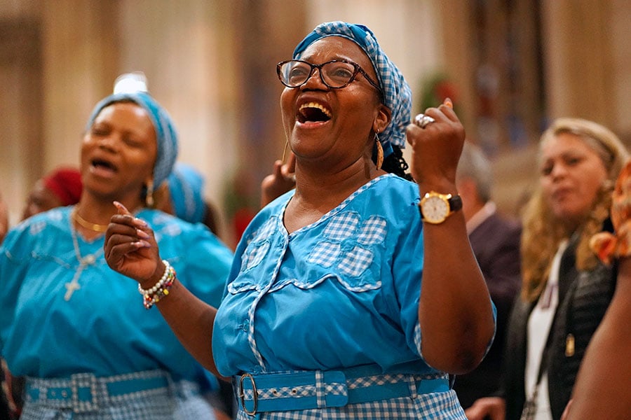 A black woman sings during a Mass